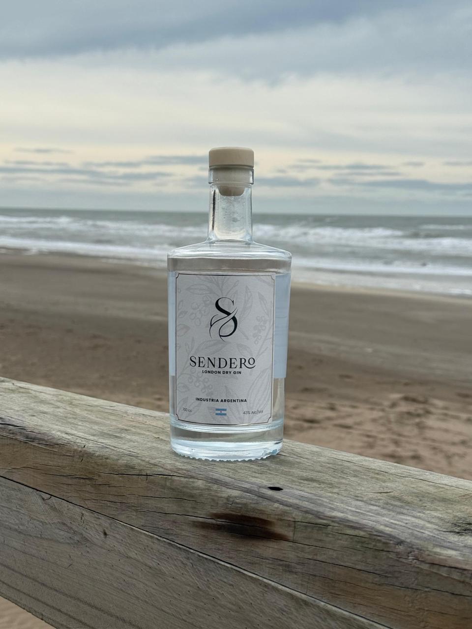 Botella de Sendero Gin frente al mar